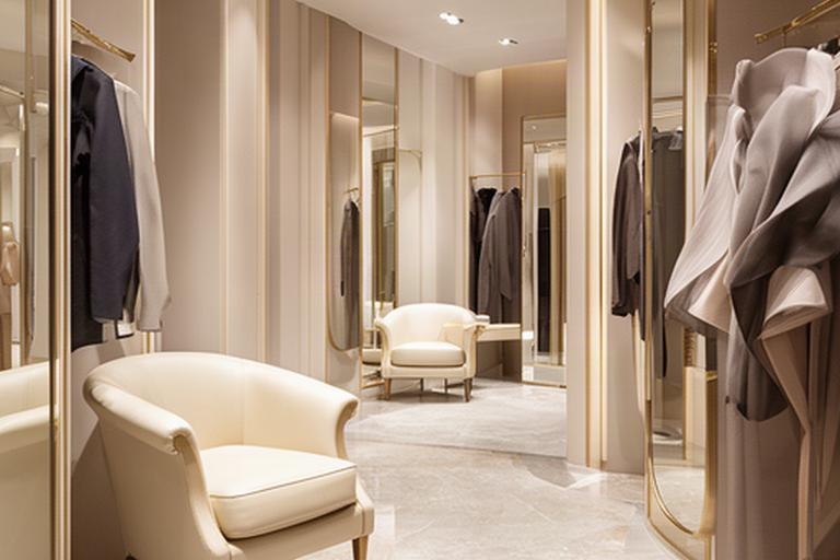 Boutique di lusso in via Montenapoleone con poltrone in pelle color crema e dettagli in ottone